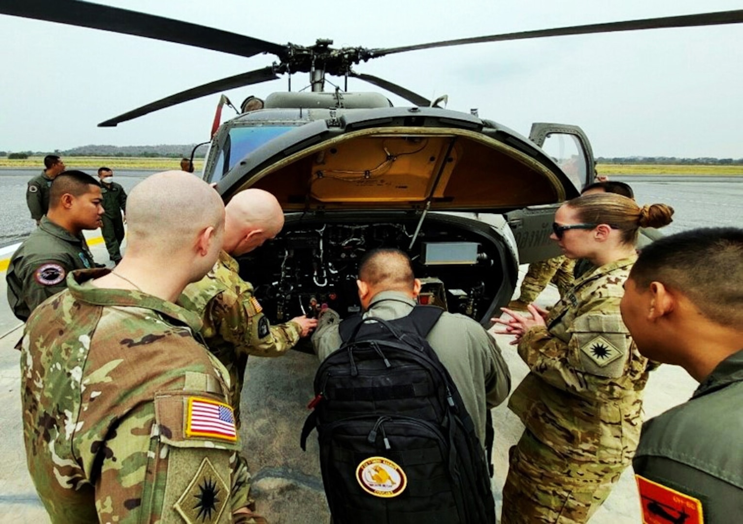 Lt. Col. Ben Gering and Staff Sgt. Rose Barton, 1st Battalion, 168th General Support Aviation, Washington National Guard, inspect the nose section of a UH-60 Black Hawk helicopter with the Royal Thai Army Maintenance Platoon March 21, 2023, in Lop Buri, Kingdom of Thailand.