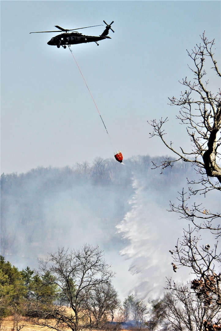 A Wisconsin Army National Guard UH-60 Black Hawk aircrew with the 1st Battalion, 147th Aviation Regiment, trains to drop water on wildfires April 10, 2023, using a bucket at Fort McCoy, Wis.