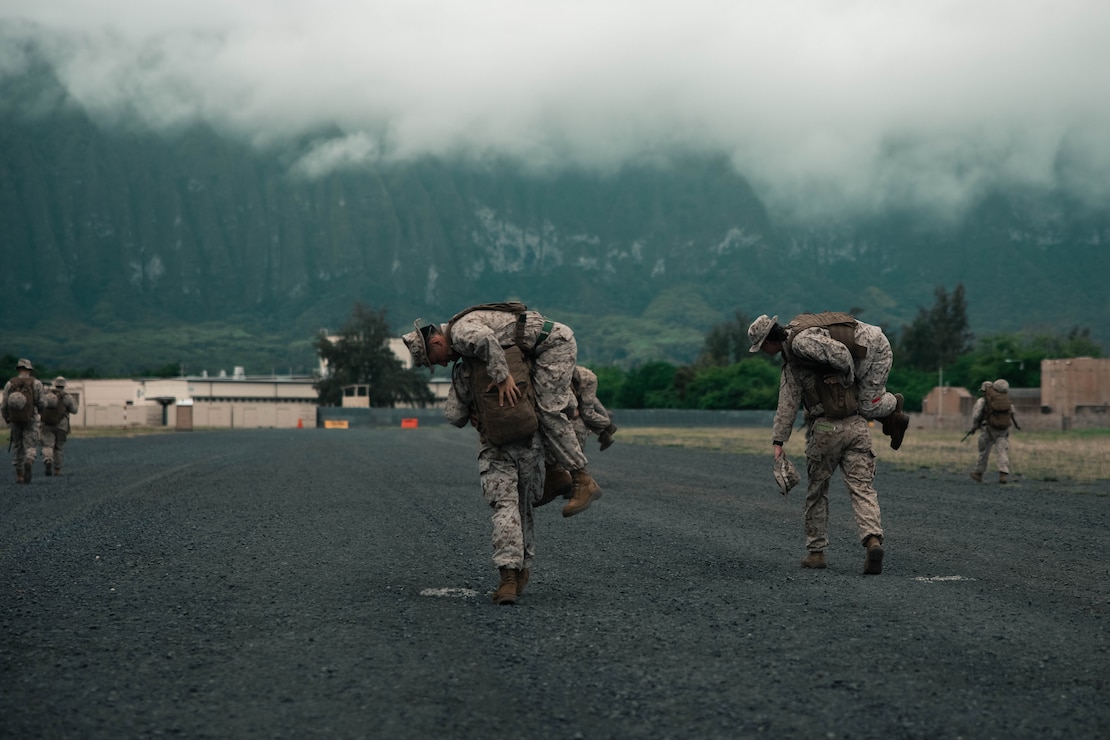 U.S. Marines stationed at Marine Corps Base Hawaii escort simulated casualties to safety in a combat evacuation patrol during the Marine Corps Air Station Kaneohe Bay Corporals Course 2-23, Marine Corps Training Area Bellows, MCBH, April 7, 2023. The course was held to provide Marine noncommissioned officers with the skills and knowledge necessary to become successful small-unit leaders.