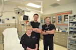 Dr. Vicki Lanier, Womack Army Medical Center deputy commander of Emergency Services and Department of Emergency Medicine chief, pose for a photo with attending physicians Christopher House and Peter Benson in WAMC trauma room, March 29, 2023.