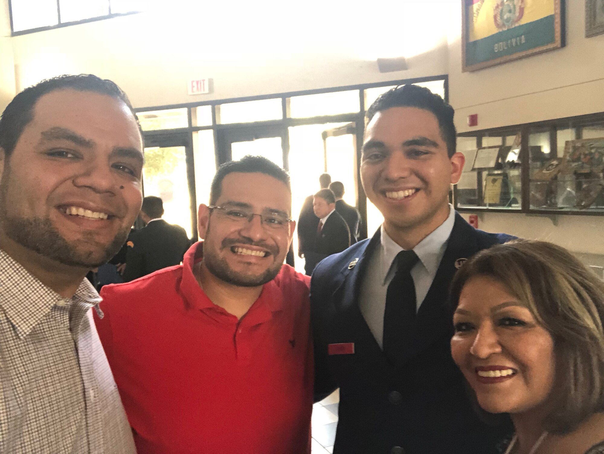 Airman poses for a selfie with two brothers and his mother inside the schoolhouse.