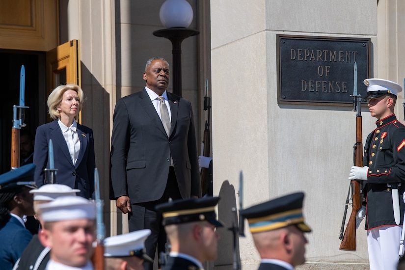 A man and a woman stand next to each other on the steps of the Pentagon during a ceremony.