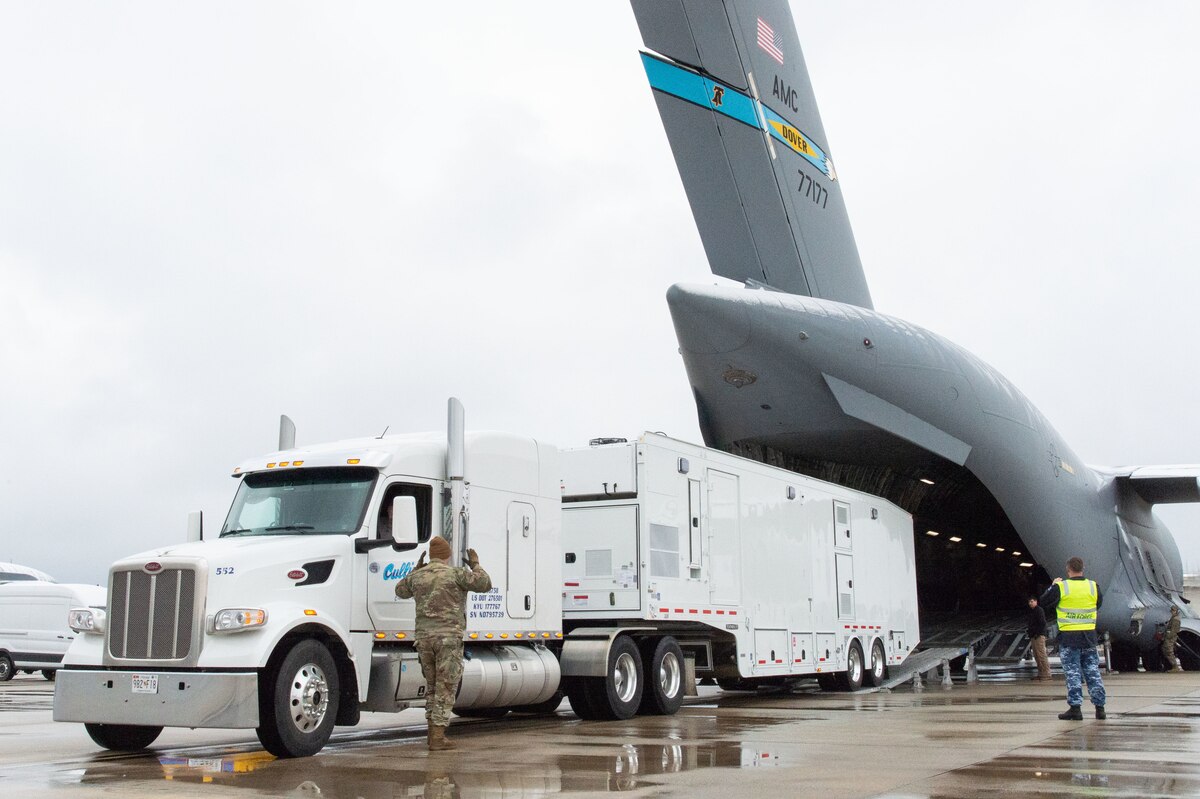 Senior Airman Joel Dooley, 436th Aerial Port Squadron expediter, marshals a Mobile Remote Quick Look trailer onto a C-17 Globemaster III at Dover Air Force Base, Delaware, Feb. 1, 2023. The RQL trailer was transported to Andersen AFB, Guam in support of the U.S. Navy MQ-4C Triton Orbit 1 operation. The MQ-4C is an unmanned aerial vehicle operated by the U.S. Navy for maritime patrol supporting intelligence, surveillance and reconnaissance operations. (U.S. Air Force photo by Roland Balik)