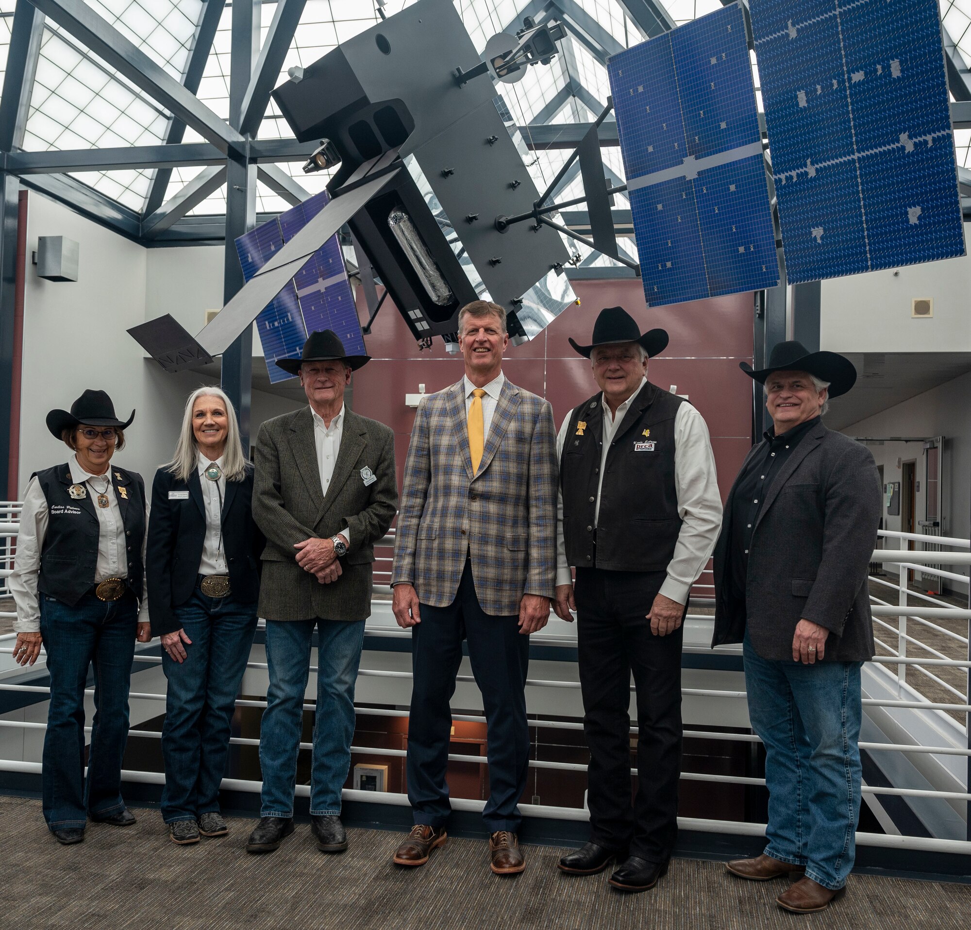 Pikes Peak Rodeo Foundation poses for a photo in front of the Space Base Infared System model, at SpOC Headquarters, Peterson Space Force Base, Colo., April 13, 2023. The Pikes Peak or Bust Rodeo has been a Colorado Springs tradition since 1937, showcasing the top rodeo talent and action. SpOC is dedicated to a continued tradition in strengthening a long-standing community relationship.  (US. Space Force photo by SSgt Jose A. Rodriguez Jr)