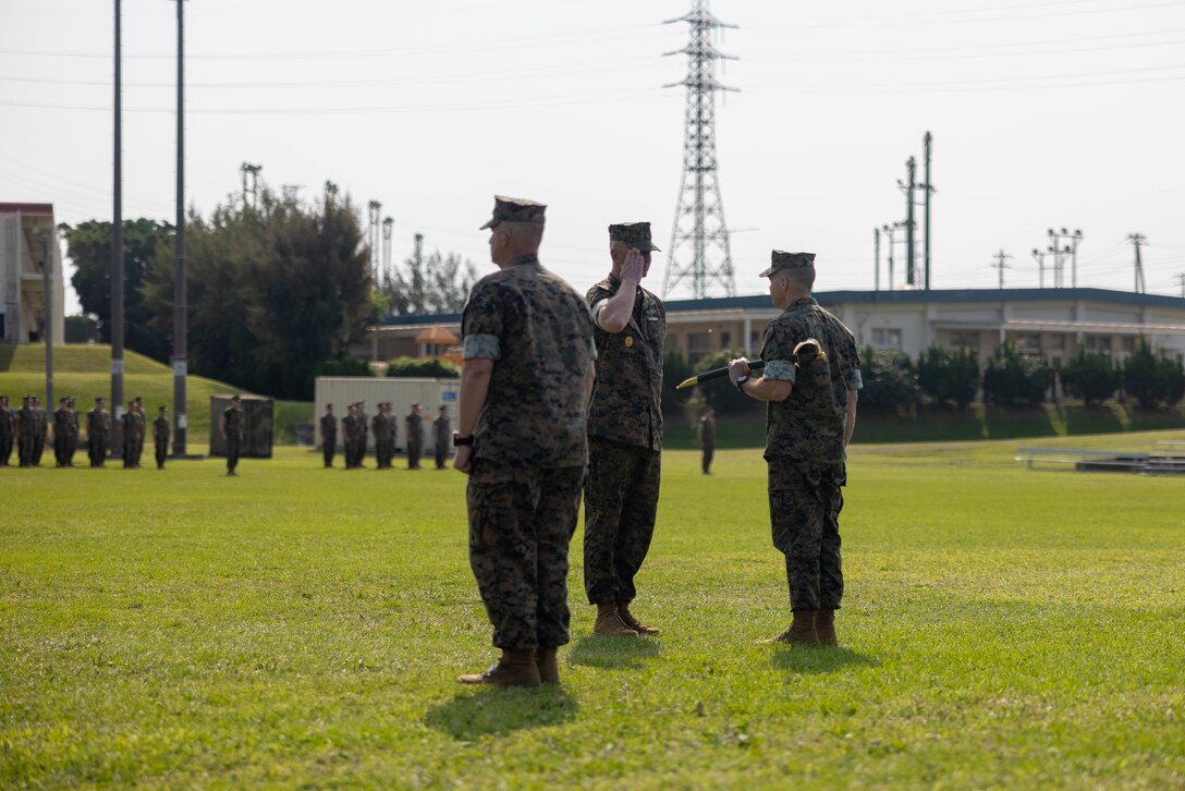 U.S. Marine Corps Maj. Gen. Jay Bargeron, right, commanding general of 3d Marine Division, prepares to pass the sword of office to U.S. Navy Master Chief Petty Officer Ben Hodges, center, oncoming Command Master Chief Petty Officer of 3d Marine Division, at a combined relief and appointment and change of charge ceremony on Camp Courtney, Okinawa, Japan, April 12, 2023. The ceremony commemorates the transfer of responsibilities from Sgt. Maj. Michael Martinet to Sgt. Maj. Robert Schieler, and from U.S. Navy Master Chief Petty Officer Donald Leppert to Hodges. (U.S. Marine Corps photo by Cpl. Diana Jimenez)