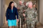 Woman in suit walks next to man in uniform