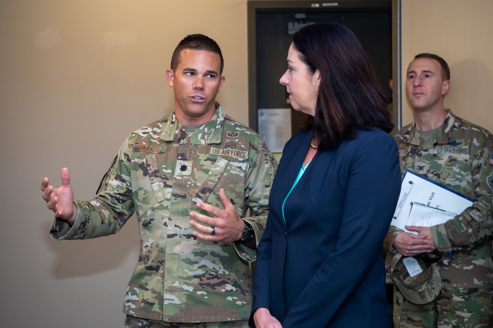 Man in uniform speaks to woman in suit