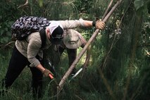 U.S. Marine Corps Staff Sgt. Leman Pendley, intelligence specialist, Joint Interagency Task Force West, cuts down an invasive plant species during a weed warriors event hosted by the Environmental Compliance and Protection Division, Marine Corps Base Hawaii, April 8, 2023. The ECPD held the event in an effort to remove invasive plant species and debris from the Nu‘upia Ponds wetlands wildlife management area. (U.S. Marine Corps photo by Cpl. Christian Tofteroo)