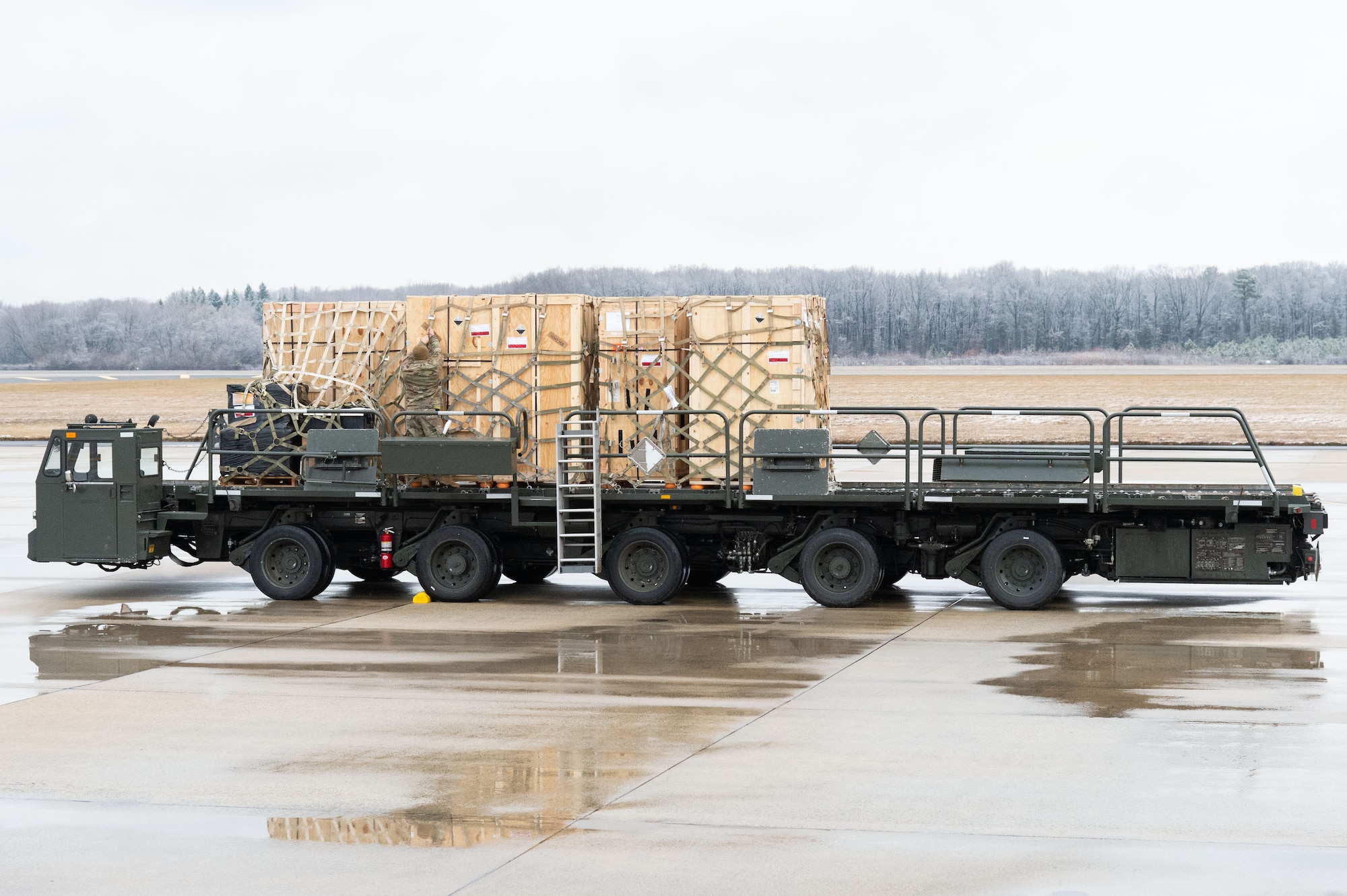 A cargo loader carrying palletized Forward Operating Base equipment sits on the flight line at Dover Air Force Base, Delaware, Feb. 1, 2023. The FOB equipment will be used to support the U.S. Navy MQ-4C Triton Orbit 1 operations at Andersen AFB, Guam. The MQ-4C is an unmanned aerial vehicle operated by the U.S. Navy for maritime patrol supporting intelligence, surveillance and reconnaissance operations. (U.S. Air Force photo by Roland Balik)