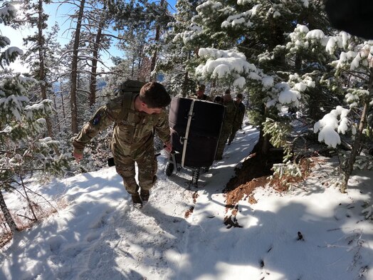  PETERSON SPACE FORCE BASE, Colorado - Members from Space Delta 3's Quick Reaction Force transport equipment up Mt. Muscoco. The QRF completed the Crucible event—a 4-mile, 1,292 ft. elevation gain hike—on April 6 where the team transported a 500+ pound Electromagnetic Warfare system and set up operations mountain-side, proving the agility and mobility of both the developmental system and the team. (Courtesy Photo)