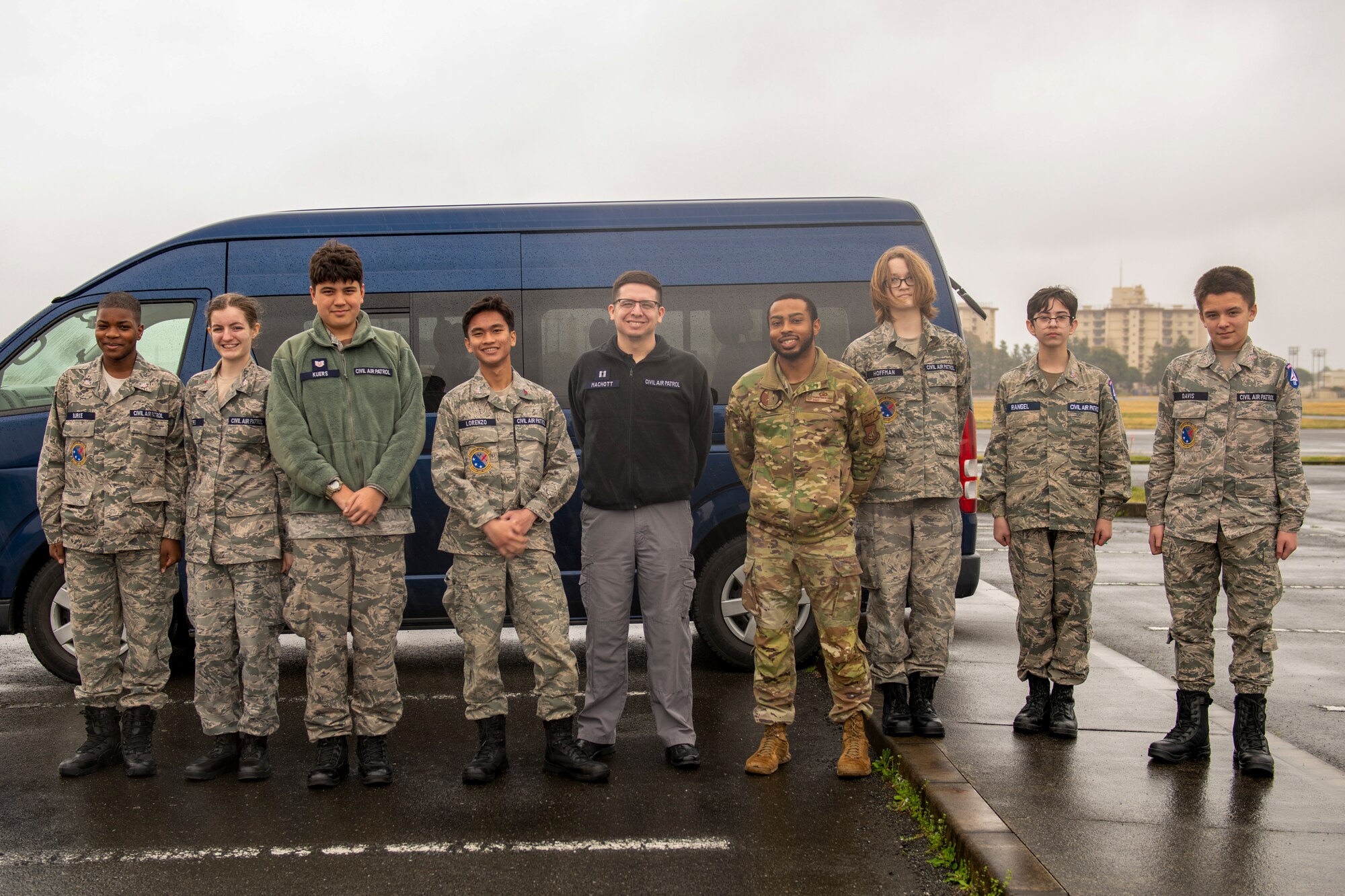kids in military uniforms line up in front of a van