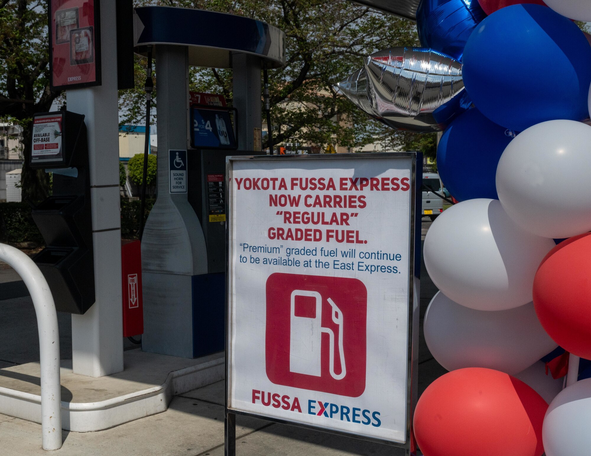 A posted sign to inform customers of a new fuel grade change in front of the gas pumps.