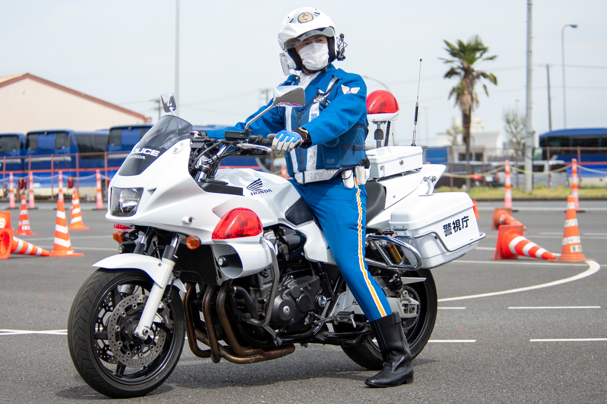 A policeman straddles a motorcycle