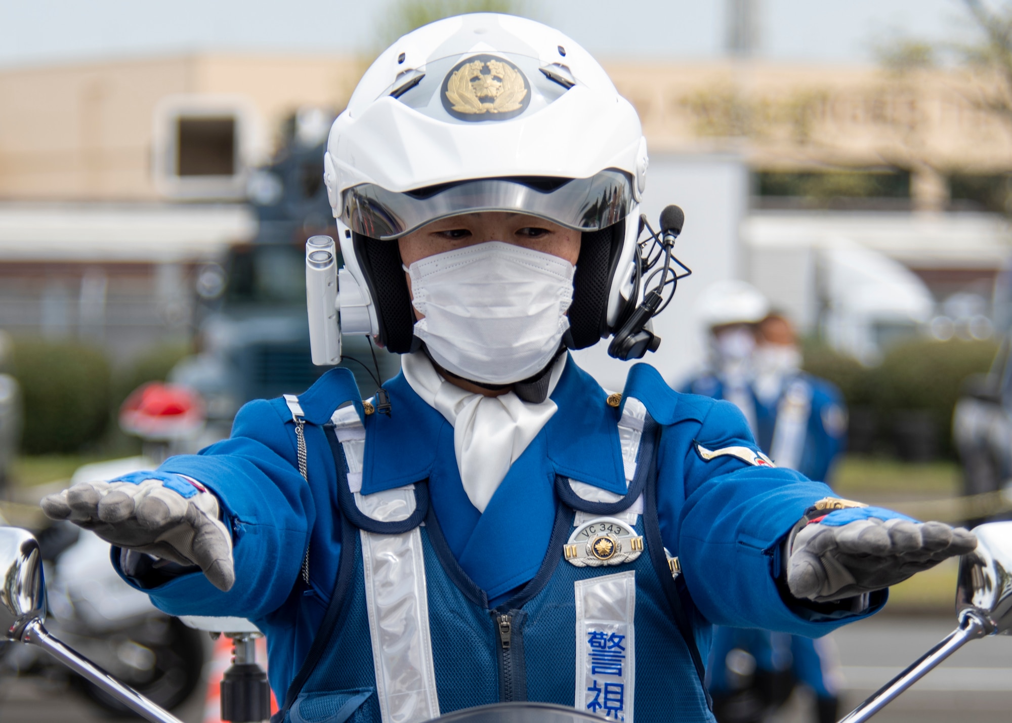 a close up of a policeman putting his hands out over the handle bars of a motorcycle he's straddling