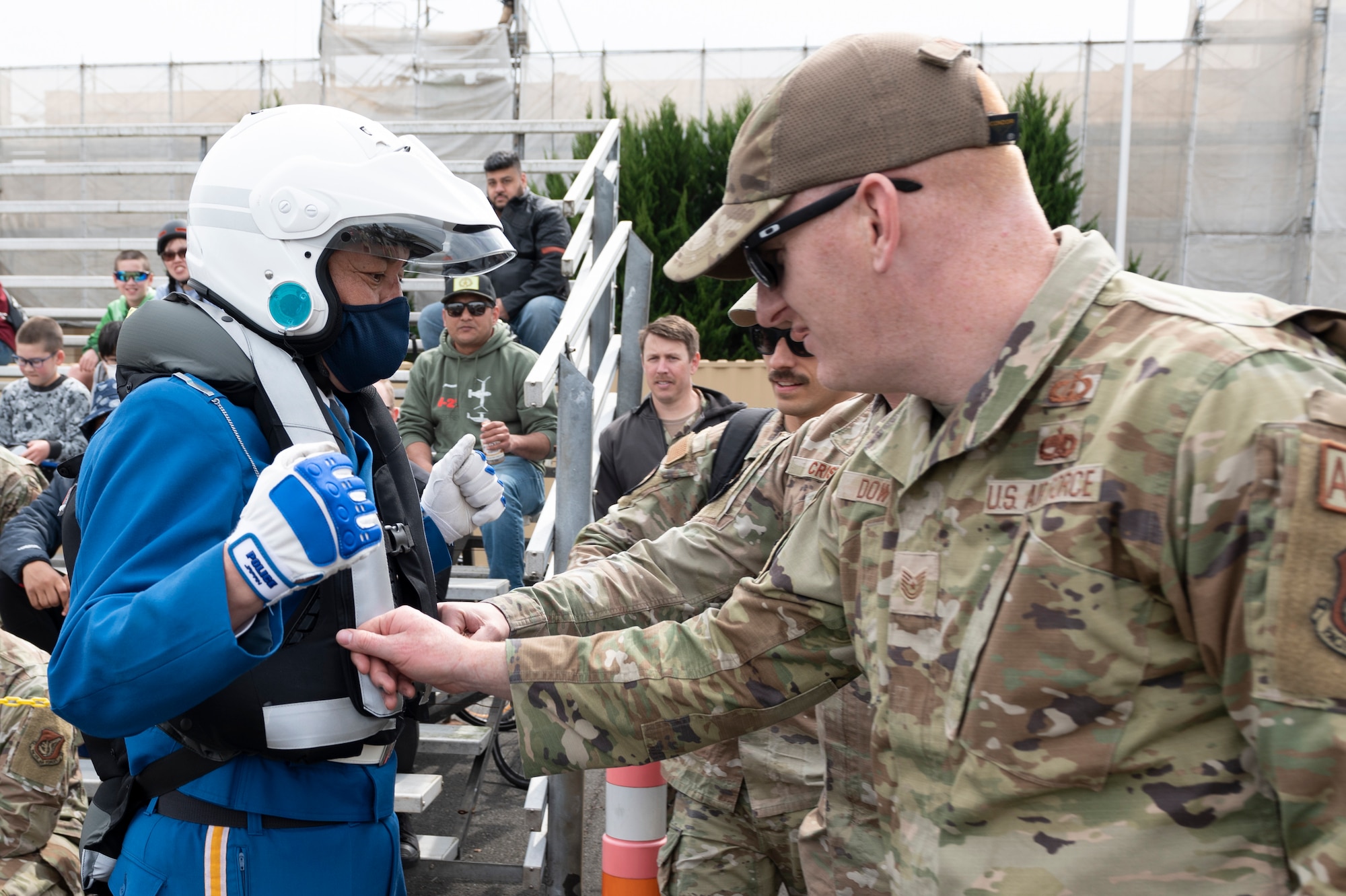 Two soldiers poke an inflatable safety vest worn by a police man