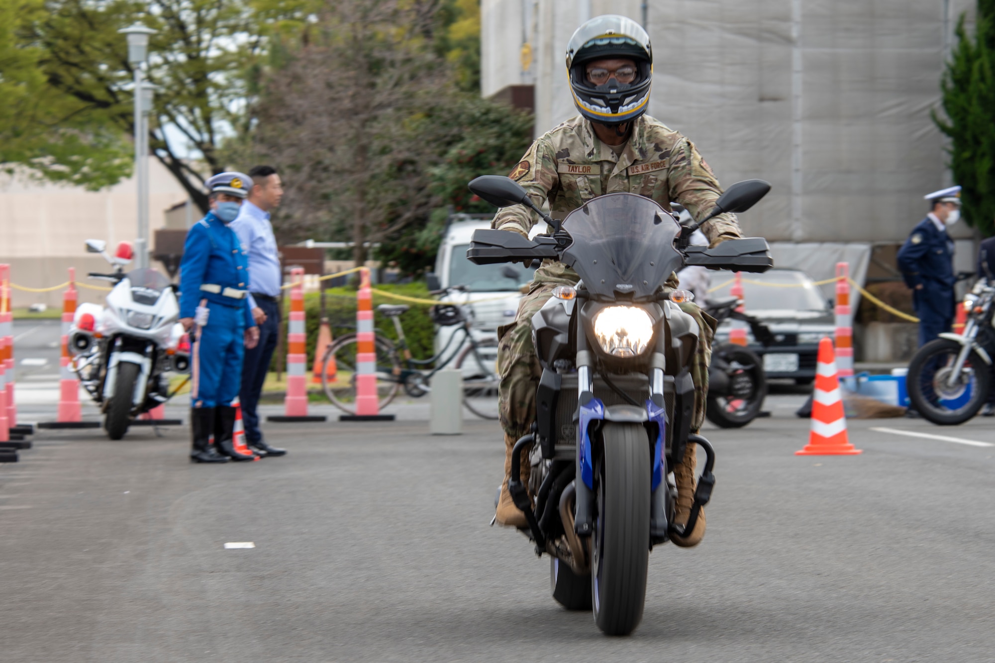 a uniformed soldier on a motorcycle drives toward the camera