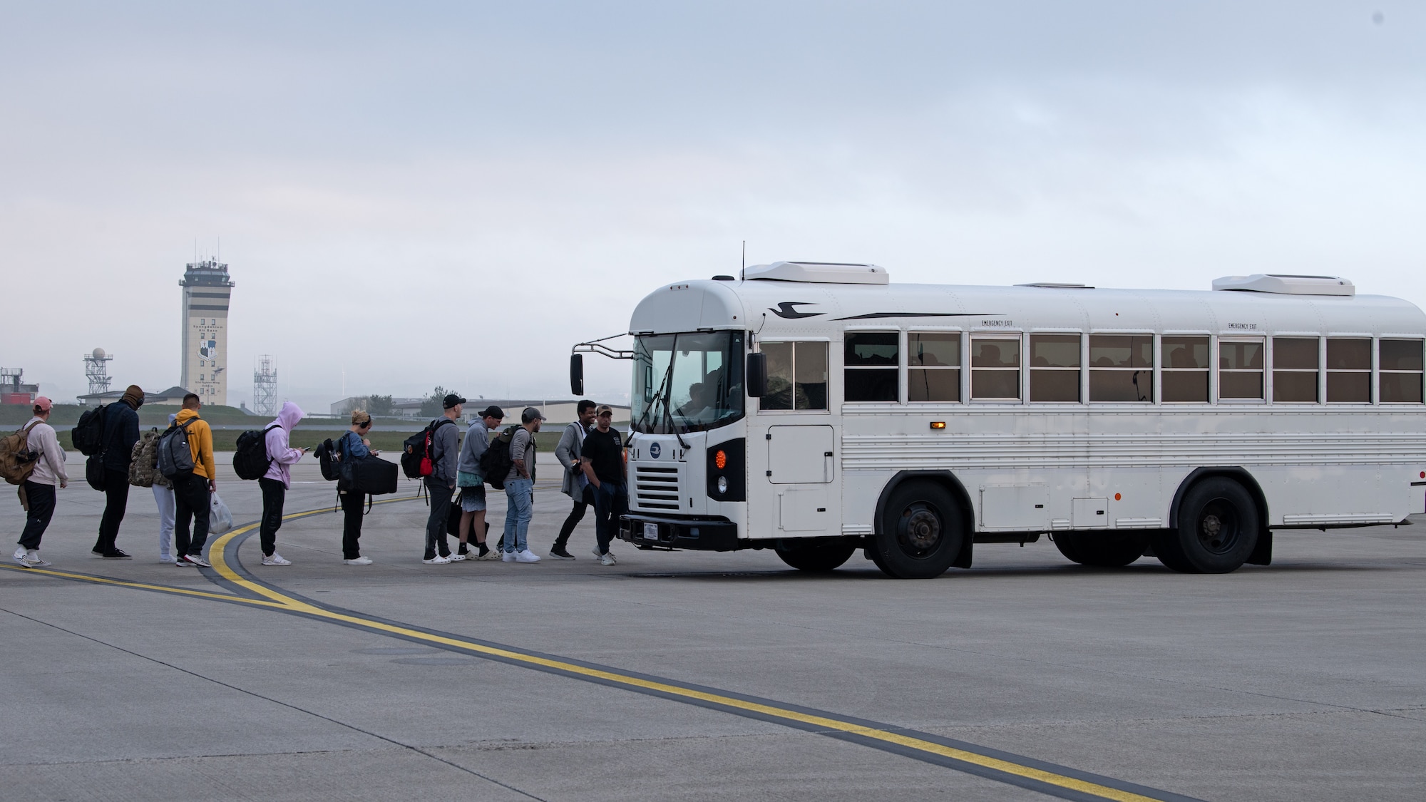 Airmen wait to board a bus.