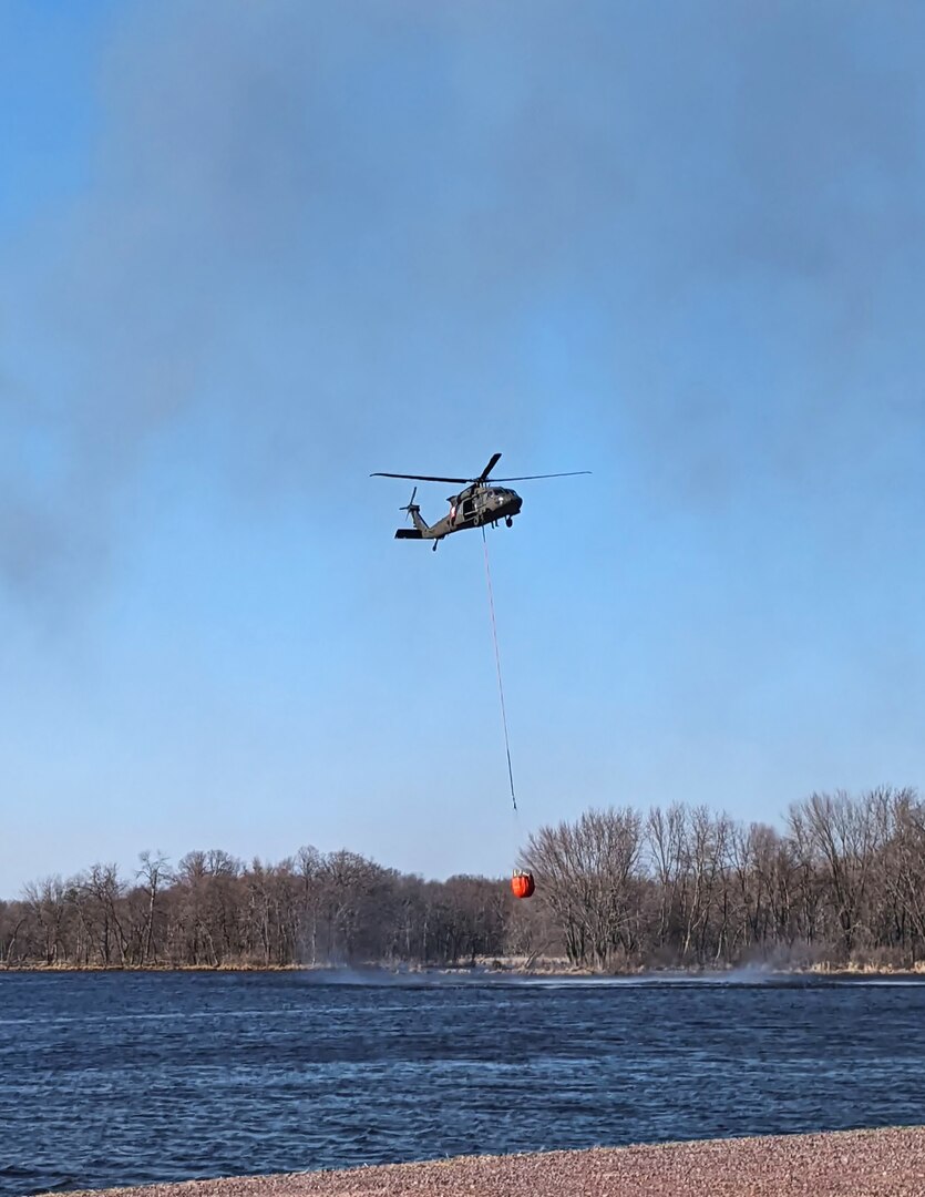 A Wisconsin Army National Guard UH-60 Black Hawk helicopter prepares to fill a bucket with water to drop on a wildfire near Necedah April 12, 2023. The fire burned more than 2,800 acres.