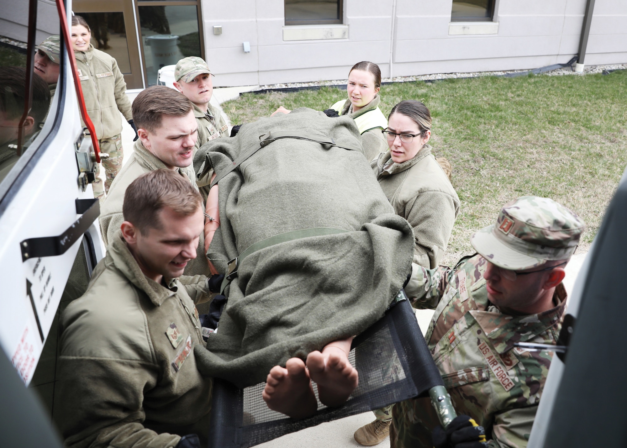 Reserve Citizen Airmen from the 445th Aeromedical Staging Squadron load a medical mannequin onto bus during mission training held during the March 12, 2023, unit training assembly. The group of medical technicians practiced preparing stable patients for transport.