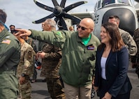 TYRRHENIAN SEA (March 22, 2023) Rear Adm. Dennis Velez, left, commander, Carrier Strike Group (CSG) 10, George H.W. Bush Carrier Strike Group, and Natasha Franceschi, U.S. Deputy Chief of Mission, U.S. Embassy Tunis observe the Electronic Attack Squadron (VAQ) 140 change of command ceremony during a key leader engagement aboard the Nimitz-class aircraft carrier USS George H.W. Bush (CVN 77), March 22, 2023. The George H.W. Bush Carrier Strike Group is on a scheduled deployment in the U.S. Naval Forces Europe area of operations, employed by U.S. Sixth Fleet to defend U.S., allied, and partner interests.