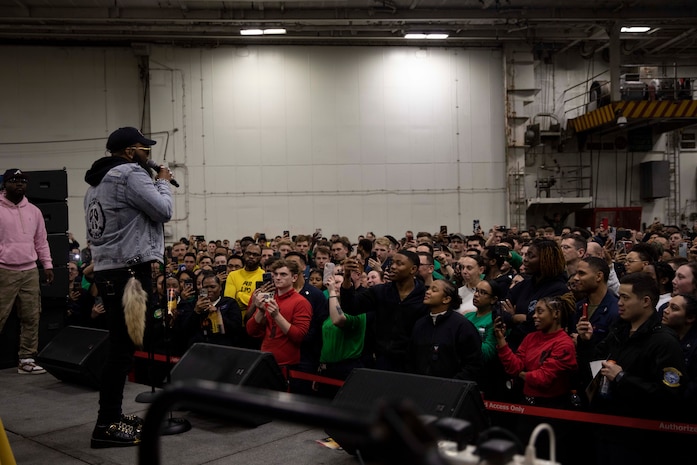 TYRRHENIAN SEA (March 25, 2023) Blanco Brown, performing artist, performs for Sailors aboard the Nimitz-class aircraft carrier USS George H.W. Bush (CVN 77) during a USO concert in the hangar bay, March 25, 2023. The George H.W. Bush Carrier Strike Group is on a scheduled deployment in the U.S. Naval Forces Europe area of operations, employed by U.S. Sixth Fleet to defend U.S., allied and partner interests.