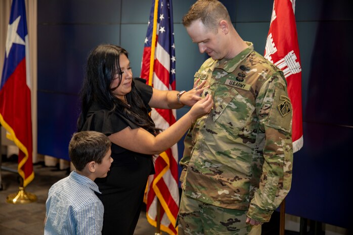 Spouse of U.S. Army Corps of Engineers Galveston District Deputy Commander for Mega Projects Lt. Col. Ian O’Sullivan places his new rank insignia on his uniform during his promotion ceremony at the district headquarters.