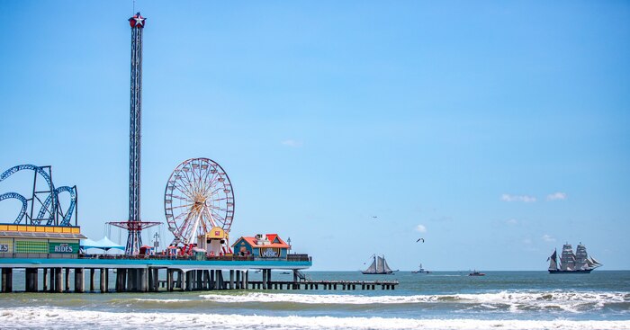 Ernestina-Morrissey, a grand banks fishing schooner and last fishing schooner built for the Wonson Fish Company, left, and Elissa, a three-masted barque and one of three ships of her kind still active, transit the Gulf of Mexico off the coast of Galveston Beach near Pleasure Pier during Tall Ships Challenge Galveston 2023.