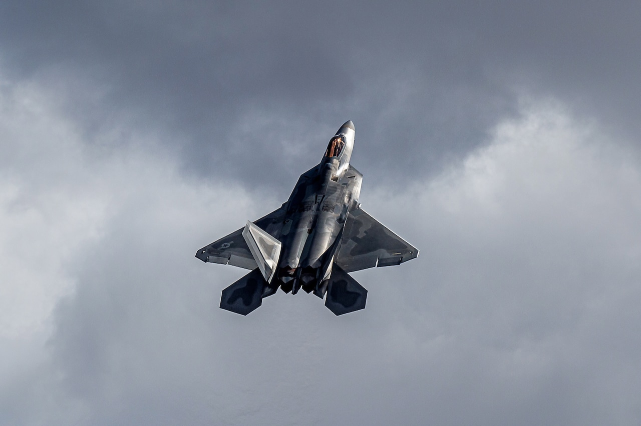 An aircraft flies up in front of clouds.