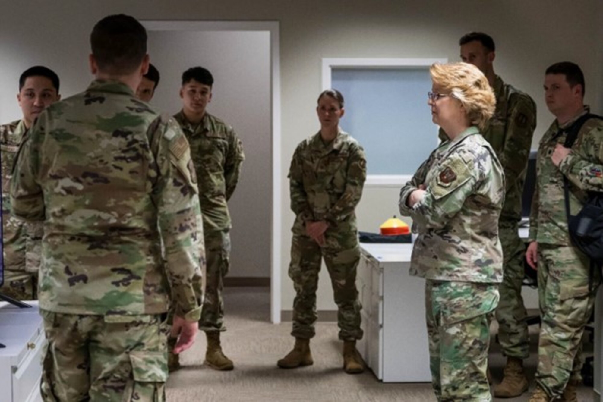 The picture depicts military members standing around Lt Gen Shipton as she receives a demo/briefing