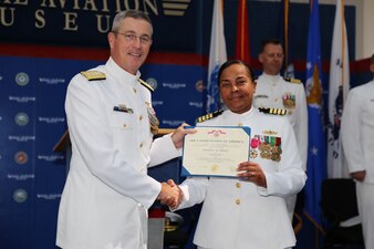 230414-N-YR423-6027 PENSACOLA, Fla. (April 14, 2023) Outgoing Naval Education and Training Professional Development Center (NETPDC) Commanding Officer Capt. Willie Brisbane (right) receives an award from Commander, Naval Education and Training Command, Rear Adm. Pete Garvin (left), during a change of command ceremony held at the National Aviation Museum onboard Naval Air Station Pensacola, April 14, 2023. Brisbane served as NETPDC’s 21st commanding officer. (U.S. Navy photo by Cheryl Dengler)