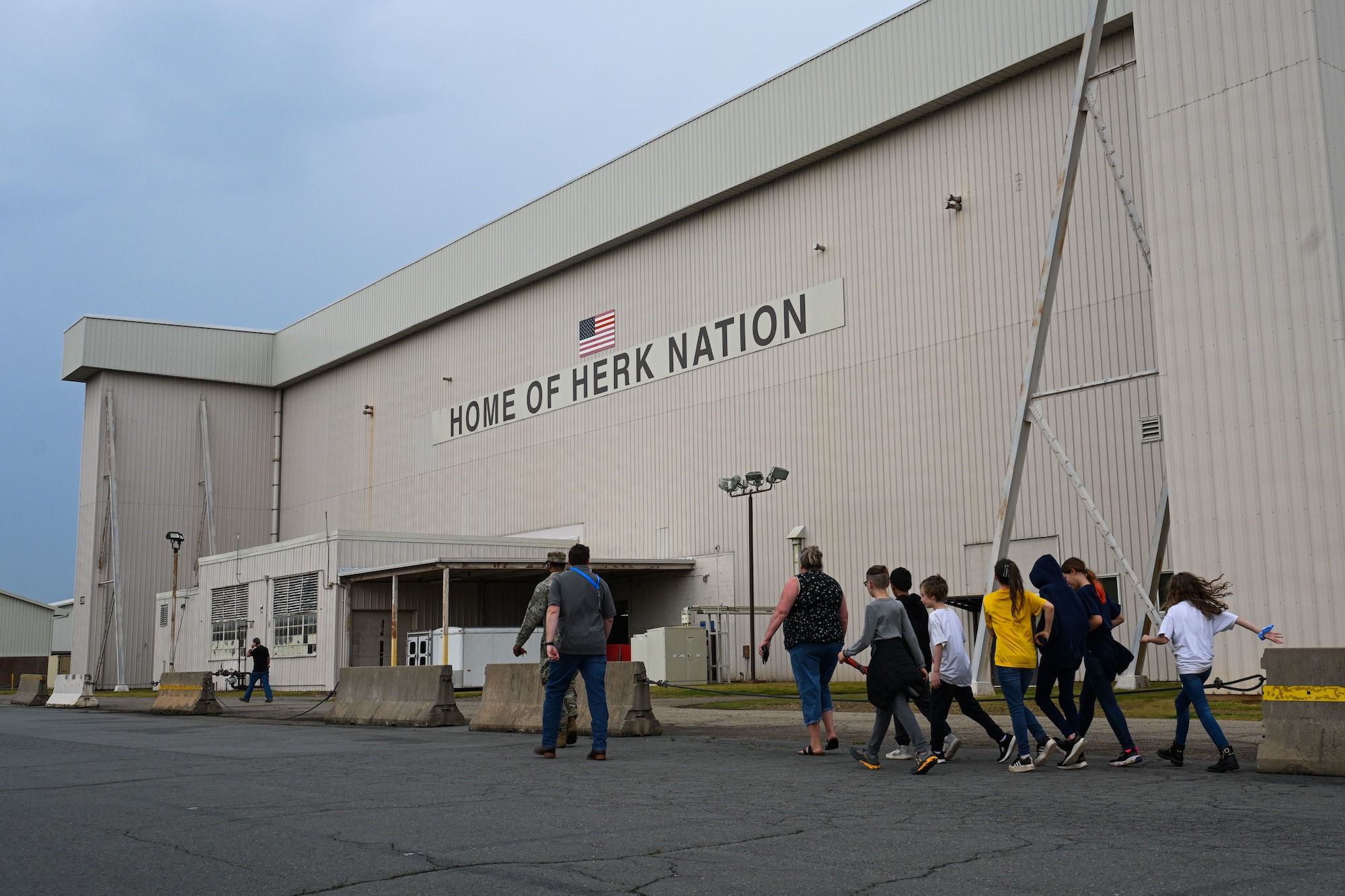 children walk inside a hangar