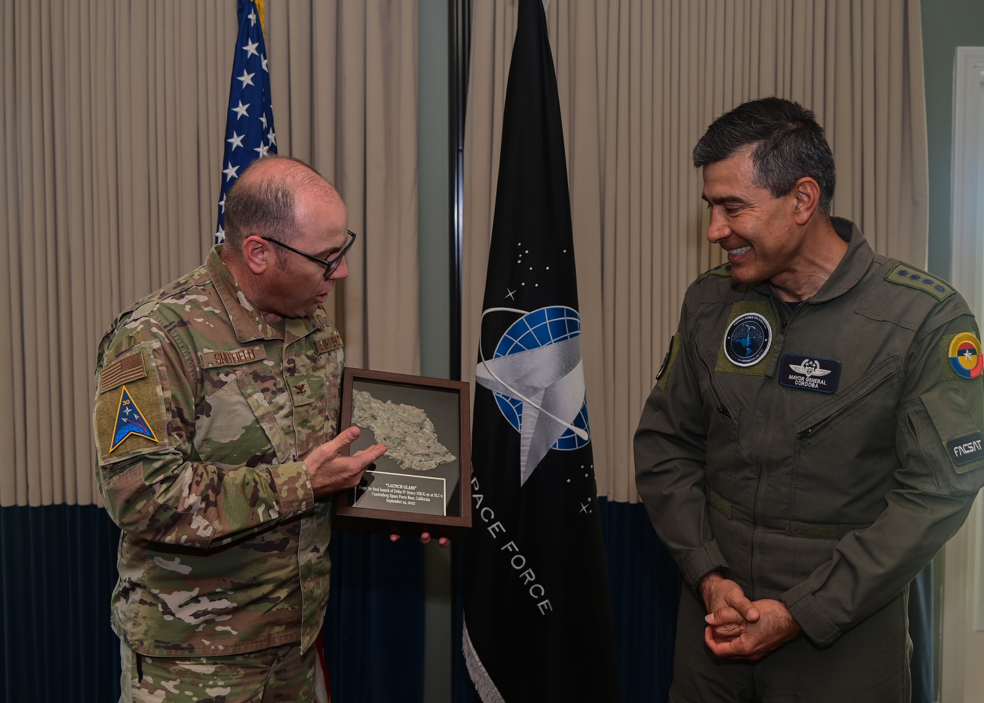 Colombian Air Force Gen. Luis C. Cordoba (right), Colombian Air Force commander, receives a piece of “launch glass” as a gift from U.S. Air Force Col. Christopher Sheffield (left), Space Launch Delta 30 vice commander, during a visit to Vandenberg Space Force Base, Calif., April 10, 2023. Gen. Córdoba led a delegation of industry and academia representatives to witness the launch of COLAF's second-ever nanosatellite in partnership with EXOLAUNCH and SpaceX. (U.S. Space Force photo by Airman 1st Class Ryan Quijas)