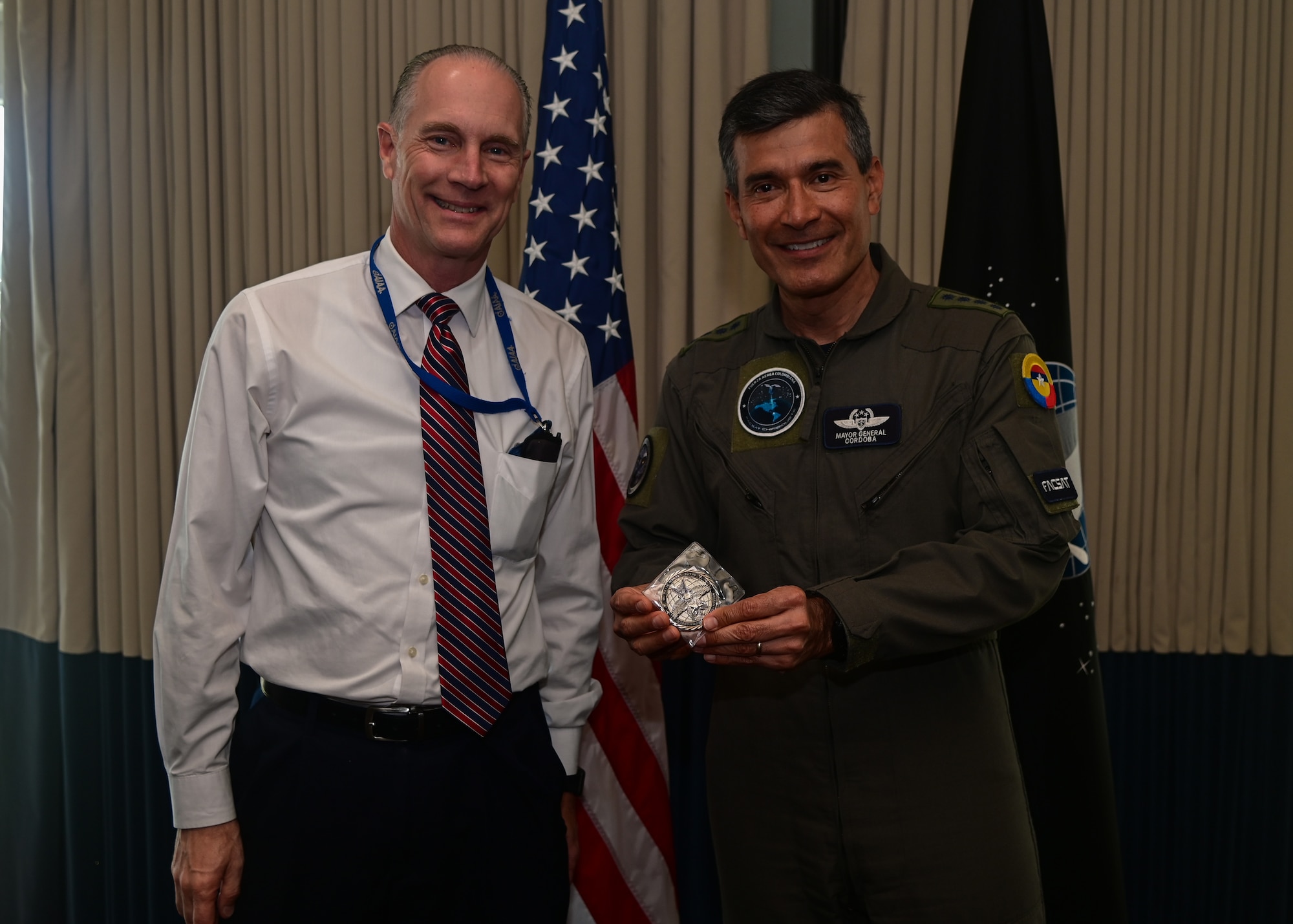 Mr. Tom Stevens (left), Space Launch Delta 30 executive director, presents a coin to Colombian Air Force Gen. Luis C. Córdoba (right), Colombian Air Force commander, during a visit to Vandenberg Space Force Base, Calif., April 10, 2023. Gen. Córdoba Gen. Córdoba led a delegation of industry and academia representatives to witness the launch of COLAF's second-ever nanosatellite in partnership with EXOLAUNCH and SpaceX. (U.S. Space Force photo by Airman 1st Class Ryan Quijas)