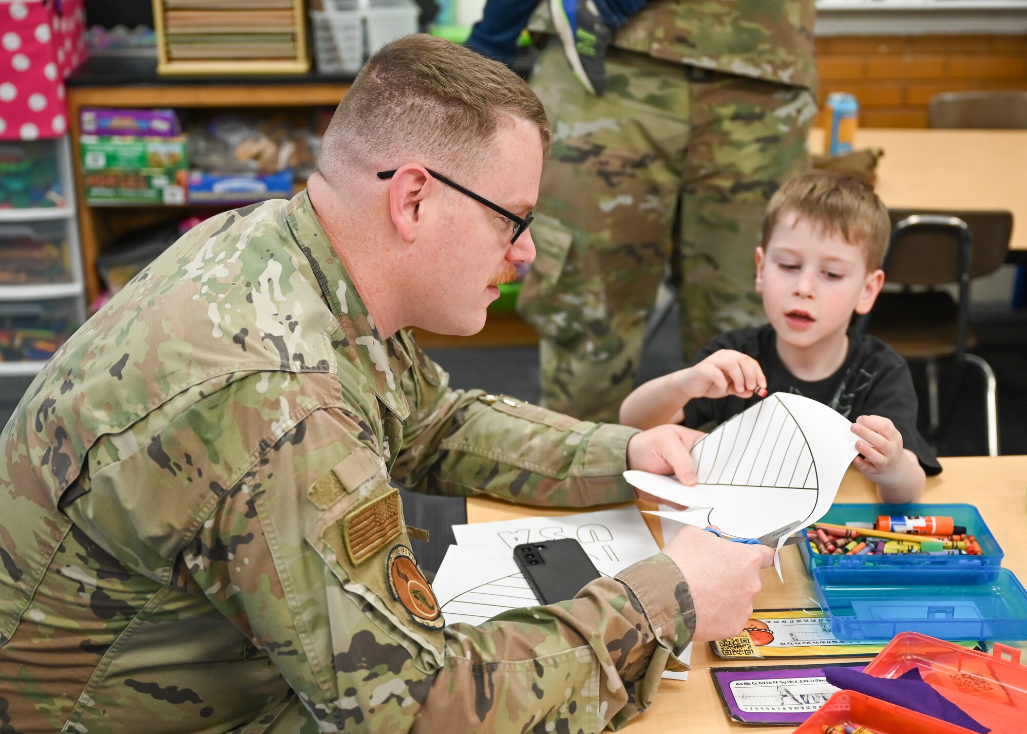 Staff Sgt. Joshua Buckley, 388th Munitions Squadron, and son Fenrin, color together