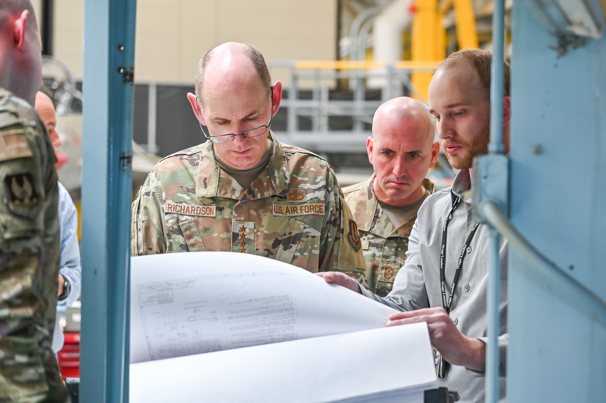 Gen. Duke Z. Richardson, Air Force Materiel Command commander, and Chief Master Sgt. David A. Flosi, AFMC command chief, listen to Matt Heiner, 573rd Aircraft Maintenance Squadron