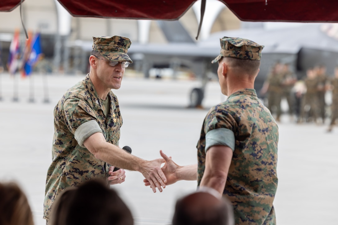 U.S. Marine Corps Col. Shannon M. Brown, commanding officer, Marine Aircraft Group 11, 3rd Marine Aircraft Wing (MAW), congratulates Lt. Col. Michael P. Fisher, commanding officer Marine Fighter Attack Squadron (VMFA) 311, during a reactivation ceremony at Marine Corps Air Station Miramar, California, April 14, 2023. The reactivation and redesignation of VMFA-311 marks the transition for the squadron to the F-35C Lightning II, which brings its unique capabilities to 3rd MAW as a long-range compliment to existing aviation assets. Formerly Marine Attack Squadron (VMA) 311, the Tomcats have made their mark on Marine Corps aviation for decades, and now will continue their legacy. (U.S. Marine Corps photo by Chief Warrant Officer 2 Trent Randolph)