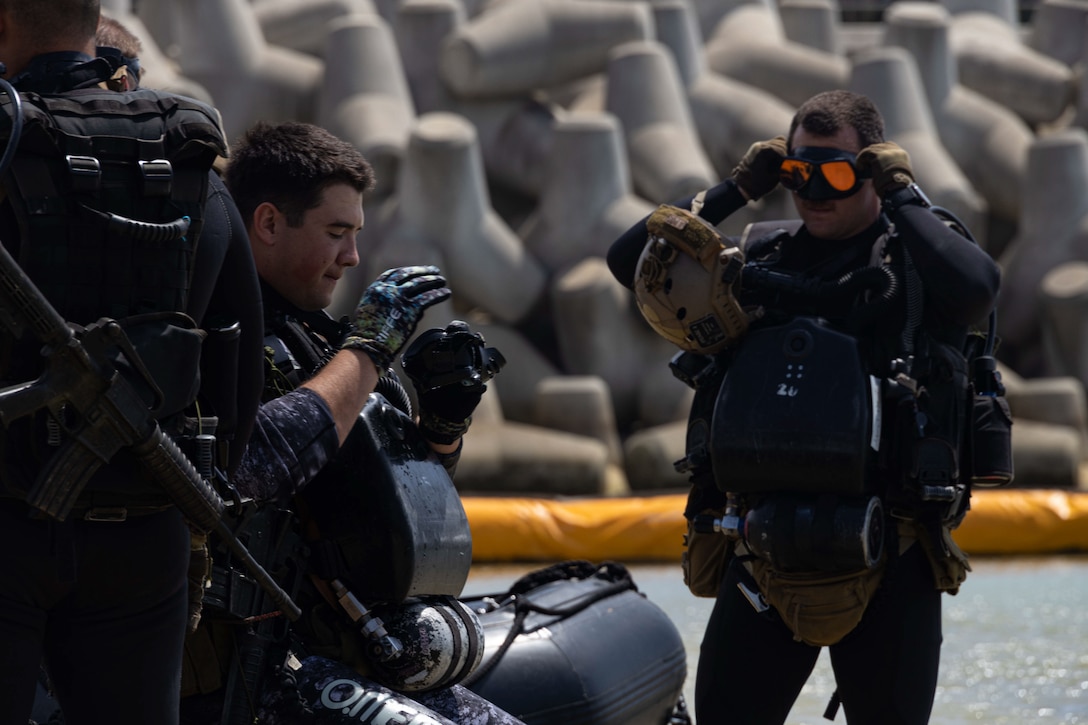 U.S. Marines with Amphibious Reconnaissance Platoon, 31st Marine Expeditionary Unit, prepare to board a combat rubber raiding craft at Camp Schwab, Okinawa, Japan April 4, 2023. The Marines conducted a diving exercise to train with diver propulsion devices as well as refine their tactical diving skills. The 31st MEU, the Marine Corps’ only continuously forward-deployed MEU, provides a ready and lethal force ready to perform a wide range of military operations as the premier crisis response force in the Indo-Pacific region. (U.S. Marine Corps photo by Sgt. Marcos A. Alvarado)