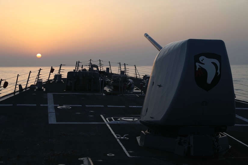 A military ship sails a body of water.