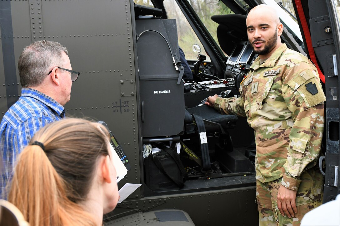 U.S. Army Warrant Officer Dejour Hughes, a UH-60 Black Hawk helicopter pilot with the 28th Expeditionary Combat Aviation Brigade, demonstrates cockpit instruments to civilian first responders at the Covington Independent Fire Company, April 15th 2023. Civil-military outreach engagements like this are designed to promote a stronger bilateral relationship with first responders and teach them unique circumstances in responding to military accidents. (U.S. Army National Guard photo by Spc. Glenn Brennan)