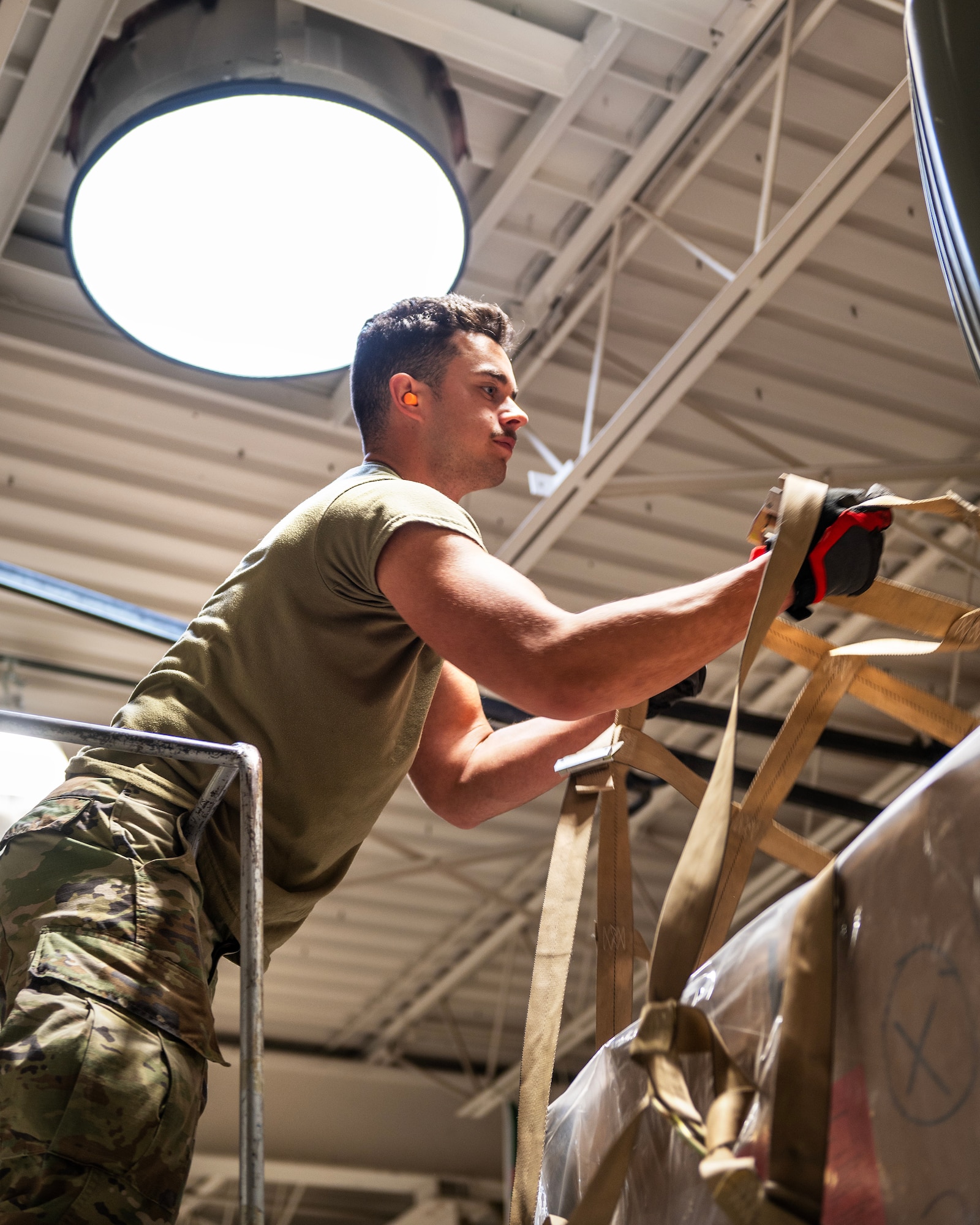U.S. Air Force Senior Airman Isaac Johnson, from the 133rd Air Transportation Function, straps down a pallet of humanitarian supplies in St. Paul, April 16, 2023.