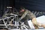 Master Sgt. Kyle Coffman of the 176th Wing, Alaska Air National Guard, loads equipment into the cargo bay of a C-17 Globemaster III, preparing to leave for a flyaway readiness exercise with the 168th Wing at Volk Field, Wisconsin, April 1, 2023. The multiday exercise focused on the Air Force’s priority of Agile Combat Employment.