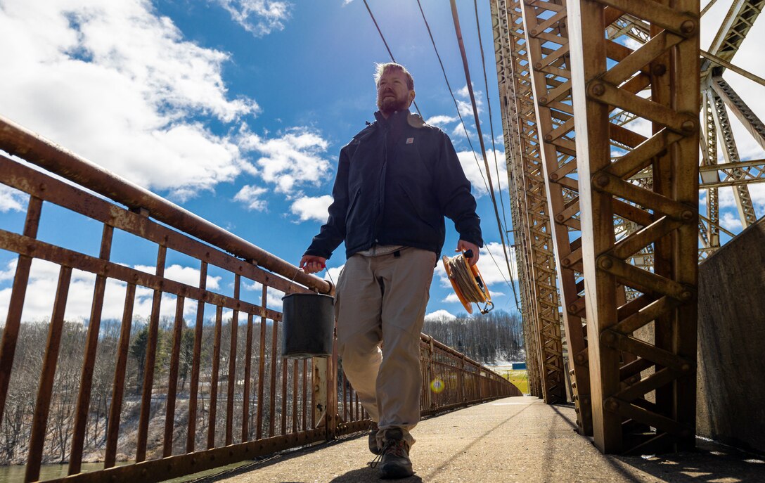 Carl Nim, a biologist with U.S. Army Corps of Engineers Pittsburgh District’s Water Quality team, carries a water sample to a mobile testing apparatus on the Tiodioute Bridge near Warren, Pennsylvania, March 30, 2023. The district’s Water Quality team collected water samples from the Allegheny River both before and after the spring pulse to compare the pulse’s effect along various points on the river. The collected samples are sent to the Corps of Engineers Research and Development Center to test and analyze myriad factors such as pH acidity, alkalinity, metals, nutrients, and conductivity. (U.S. Army Corps of Engineers Pittsburgh District photo by Andrew Byrne)