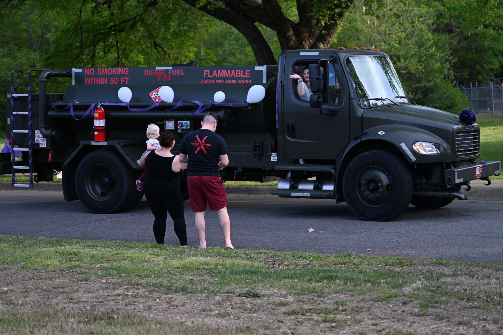 A family wave at a truck.