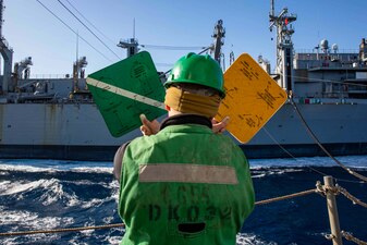 Seaman Kyle Bradshaw assigned to the Ticonderoga-class guided-missile cruiser USS Leyte Gulf (CG 55) signals replenishment complete to the fast combat support ship USNS Arctic (T-AOE 8), April 11.
