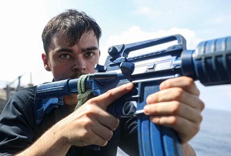 Cryptologic Technician (Technical) Seaman Logan Bunner, from Littleton, Colo., readies an M4 carbine training shape during a visit, board, search and seizure drill aboard the Arleigh Burke-class guided-missile destroyer USS Milius (DDG 69) while operating in the South China Sea, April 14.