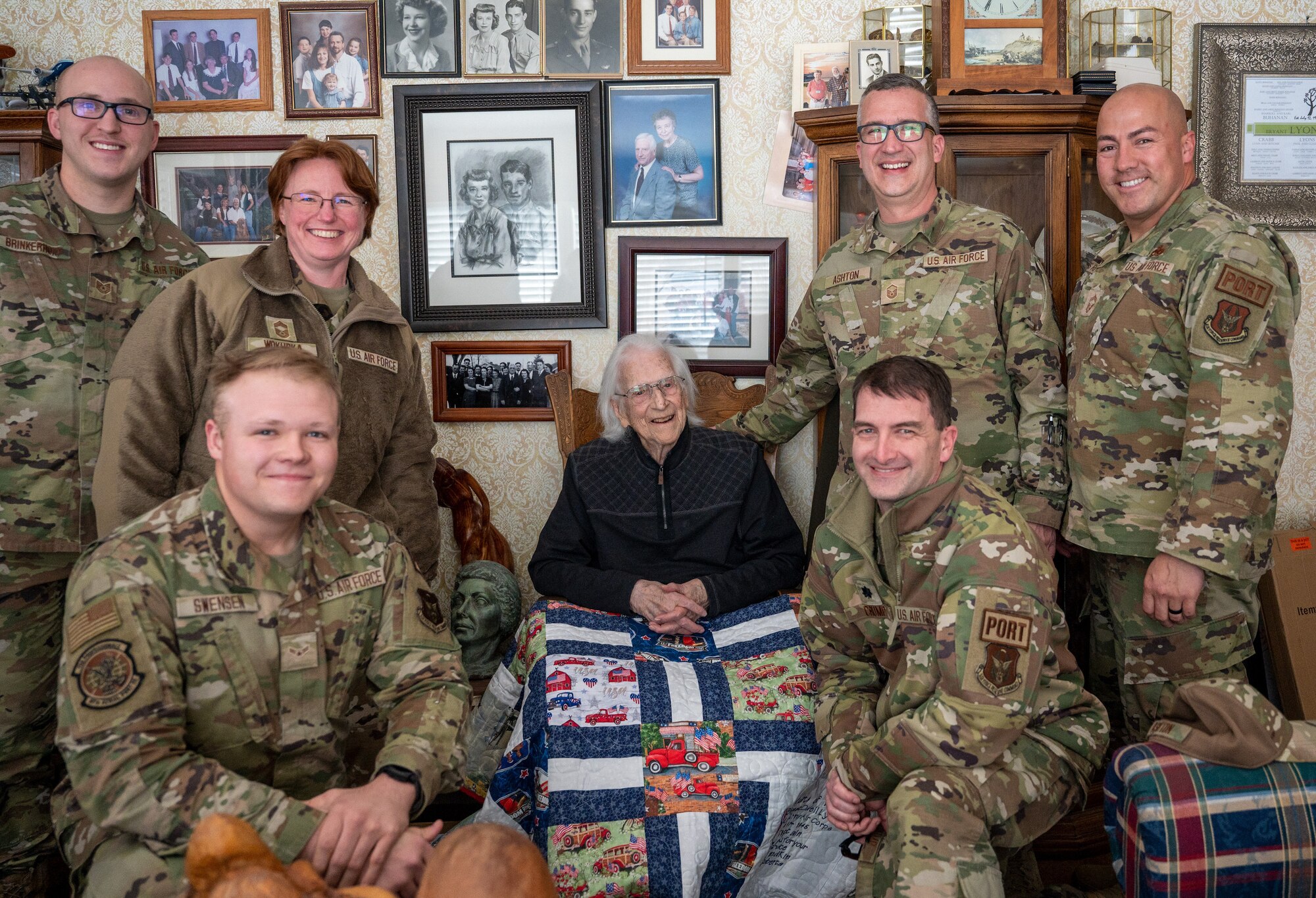 Members from the 67th Aerial Port Squadron, Hill Air Force Base, Utah pose for a photo with Retired Captain Bryant Lyons during his 100th birthday celebration on April 1, 2023, in Ogden, Utah