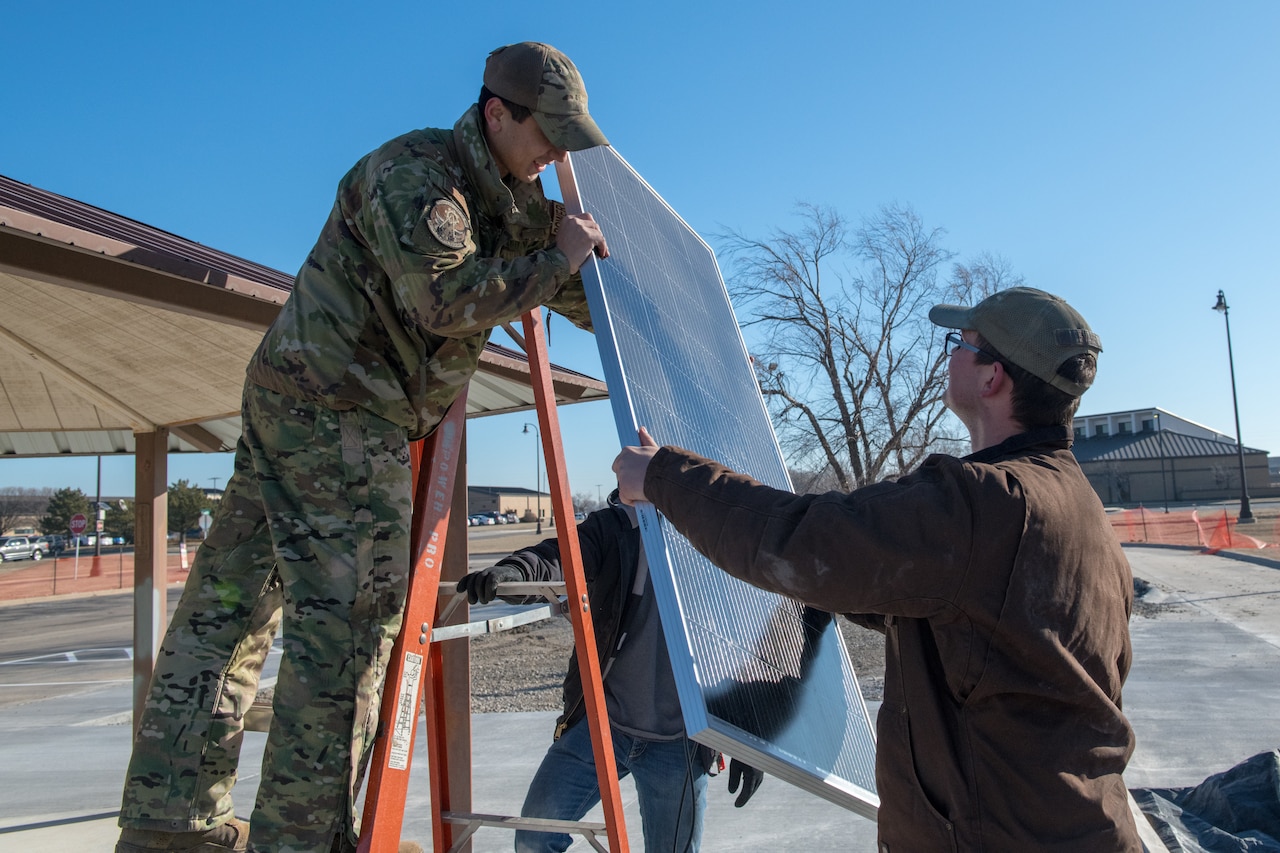 Airmen install a solar panel.