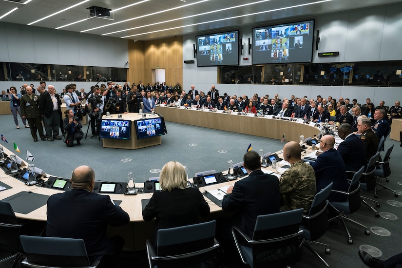 Officials sit at a large round table.