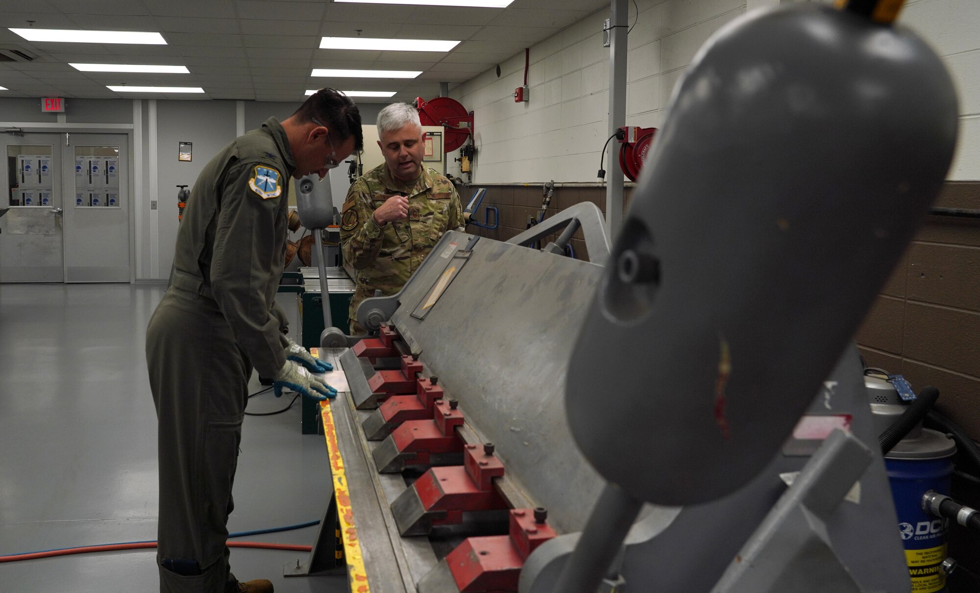 Senior Master Sgt. explains how to operate the machine used to bend sheet metal.