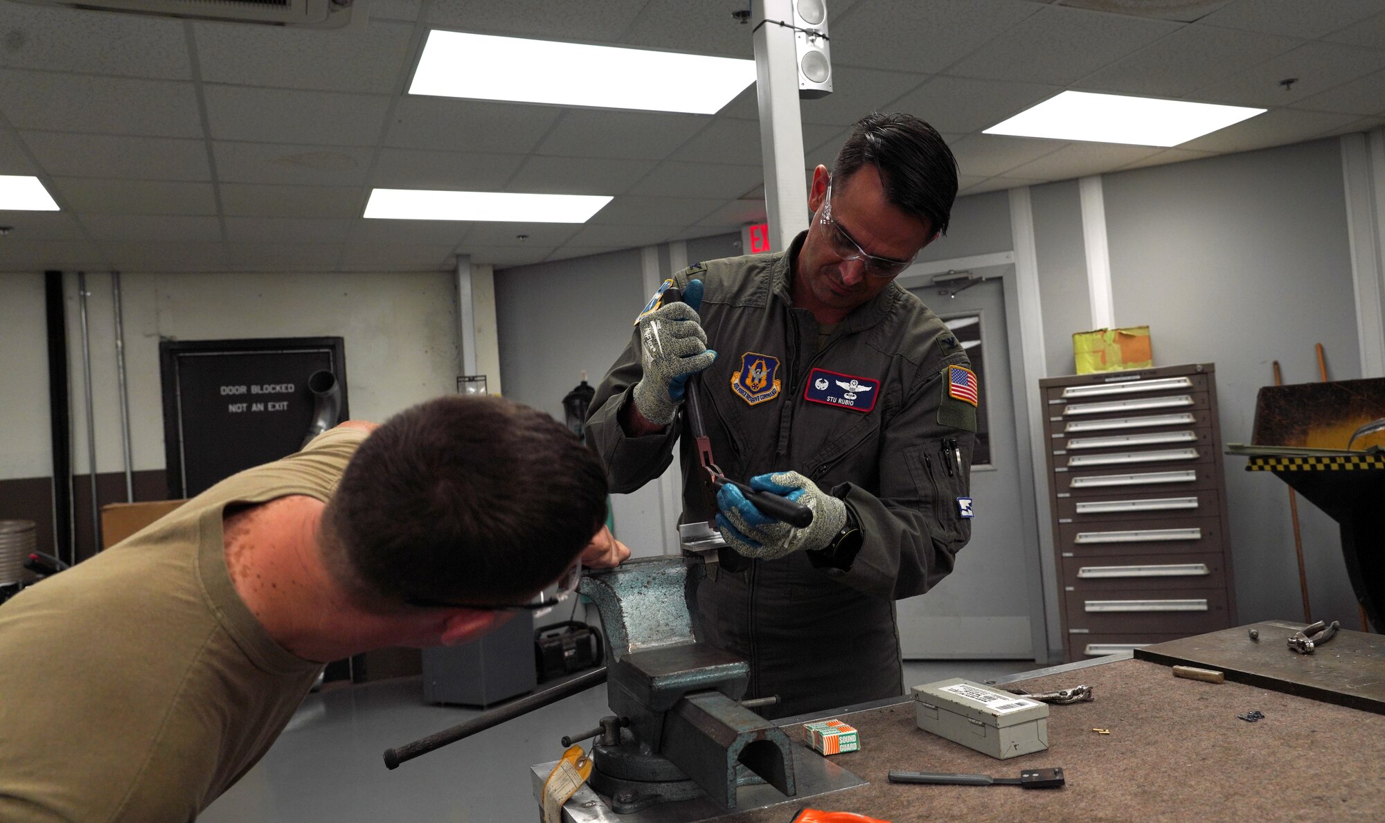 Master Sgt. explains to the commander how to use the solid rivets and hand rivet squeezers.